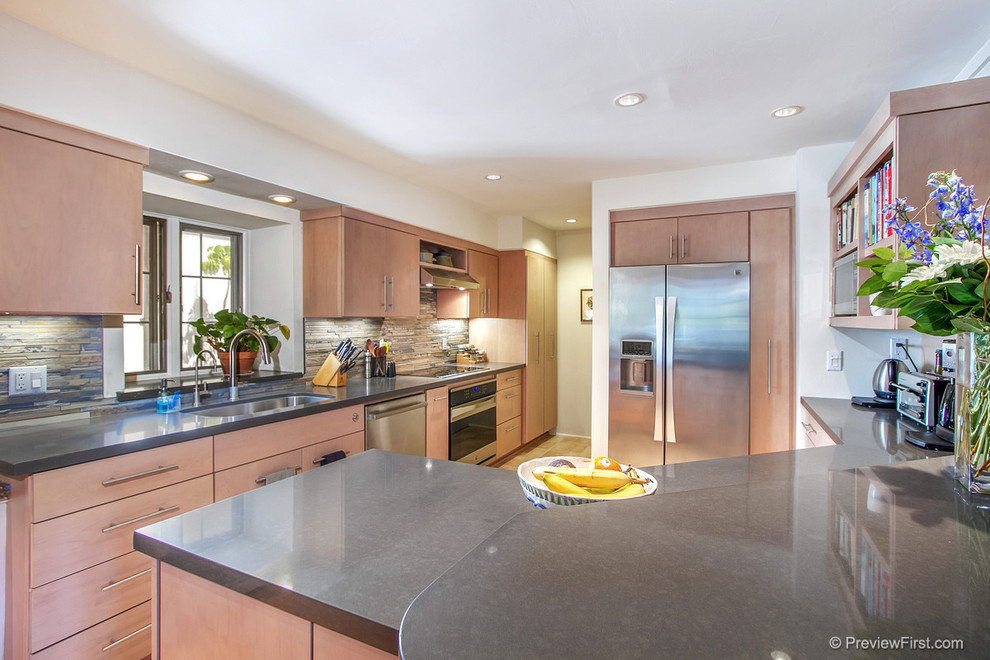 Example of a mid-sized trendy galley light wood floor eat-in kitchen design in San Diego with an undermount sink, flat-panel cabinets, light wood cabinets, quartz countertops, multicolored backsplash, matchstick tile backsplash, stainless steel appliances and a peninsula