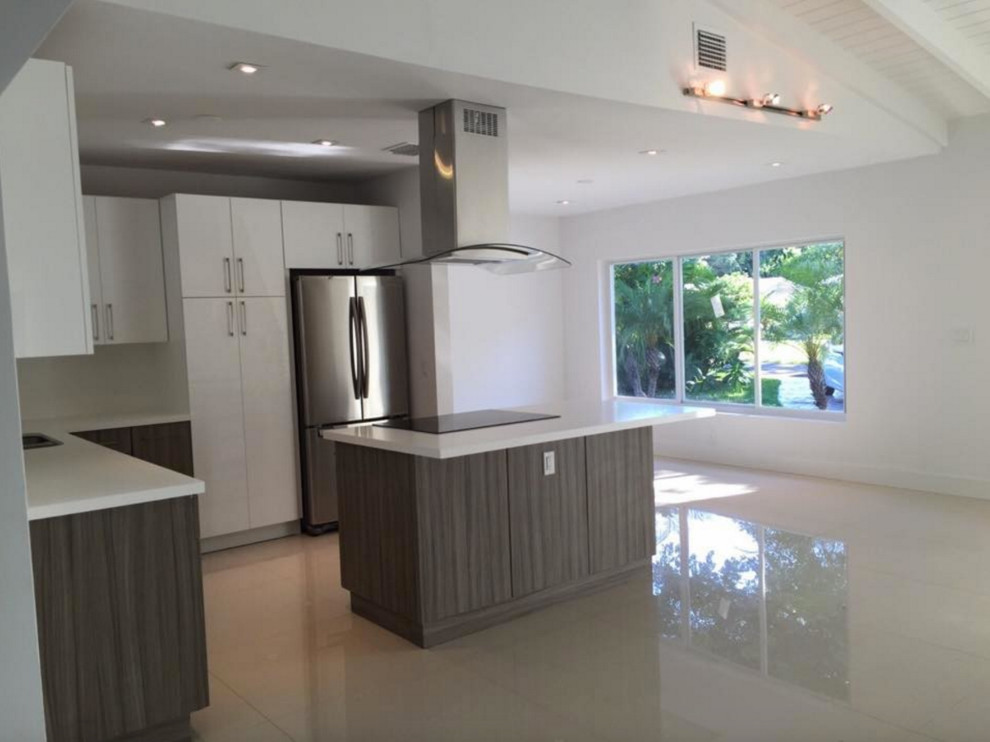 Photo of a large traditional l-shaped kitchen/diner in Miami with flat-panel cabinets, white cabinets, stainless steel appliances, lino flooring and an island.