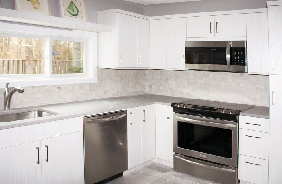 Foto på ett litet funkis grå kök, med en undermonterad diskho, släta luckor, skåp i slitet trä, bänkskiva i koppar, grått stänkskydd, stänkskydd i mosaik, rostfria vitvaror, cementgolv och grått golv