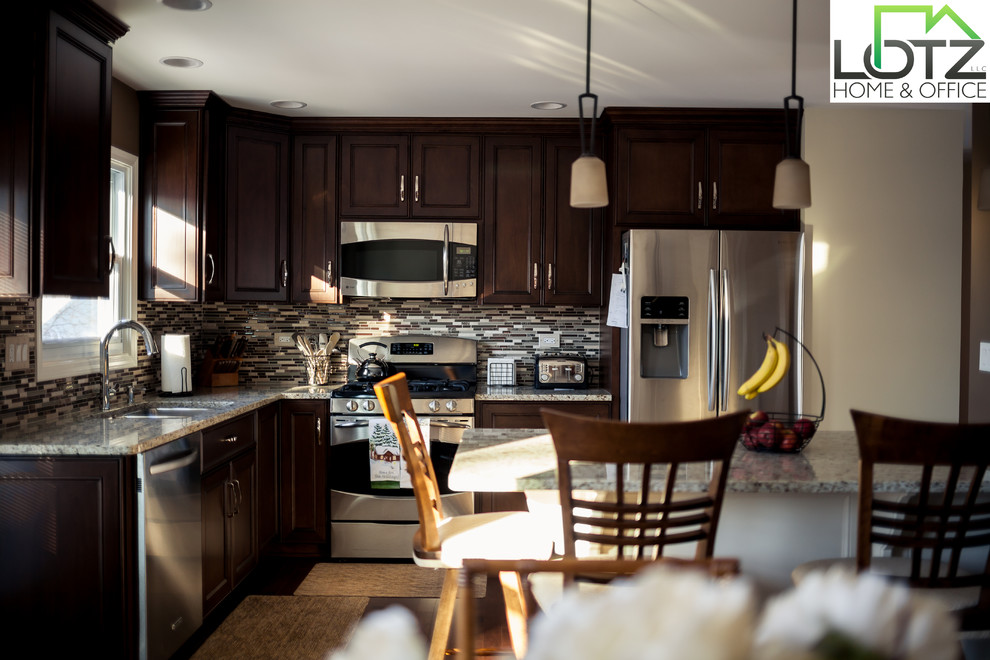 Example of a classic l-shaped eat-in kitchen design in Chicago with an undermount sink, dark wood cabinets, granite countertops, multicolored backsplash and stainless steel appliances