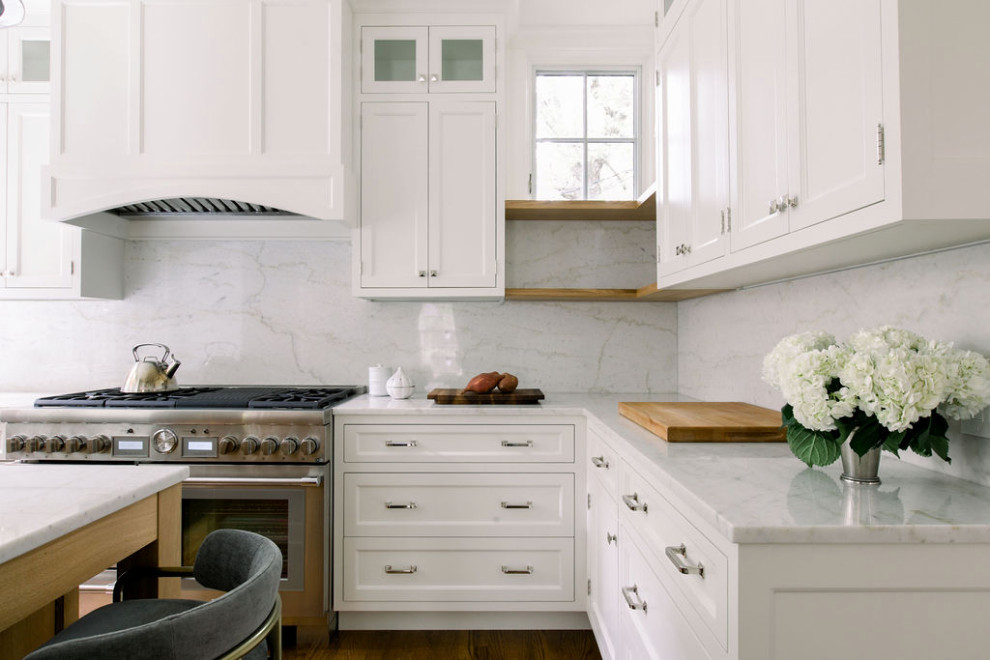 Exempel på ett mellanstort klassiskt vit vitt u-kök, med en undermonterad diskho, skåp i shakerstil, vita skåp, marmorbänkskiva, stänkskydd i marmor, rostfria vitvaror, mörkt trägolv och en köksö