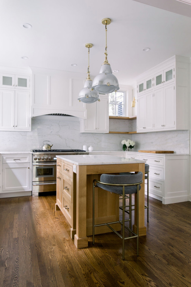 Idéer för att renovera ett mellanstort vintage vit vitt u-kök, med en undermonterad diskho, skåp i shakerstil, vita skåp, marmorbänkskiva, stänkskydd i marmor, rostfria vitvaror, en köksö, vitt stänkskydd, mellanmörkt trägolv och brunt golv