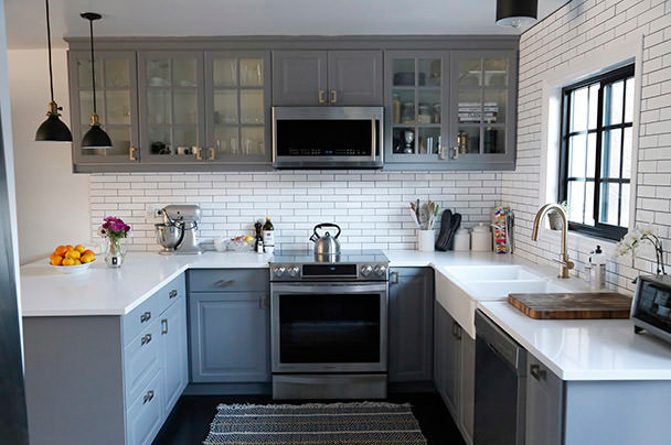 Kleine Shabby-Look Wohnküche in U-Form mit Landhausspüle, Glasfronten, grauen Schränken, Küchenrückwand in Weiß und Küchengeräten aus Edelstahl in Los Angeles