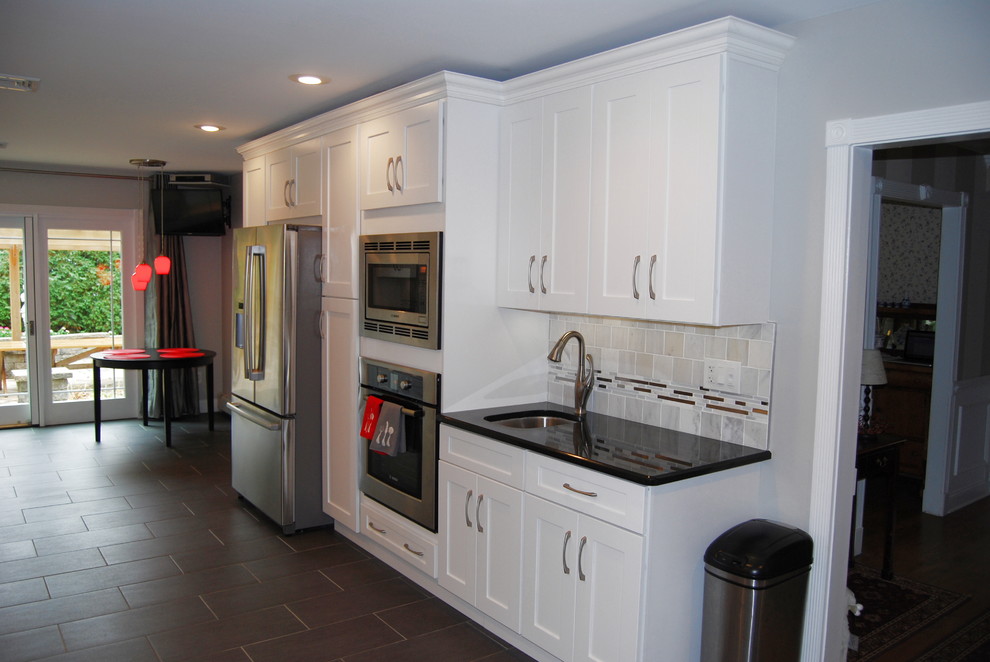 Large transitional single-wall porcelain tile enclosed kitchen photo in Philadelphia with an undermount sink, shaker cabinets, white cabinets, quartz countertops, multicolored backsplash, matchstick tile backsplash, stainless steel appliances and no island