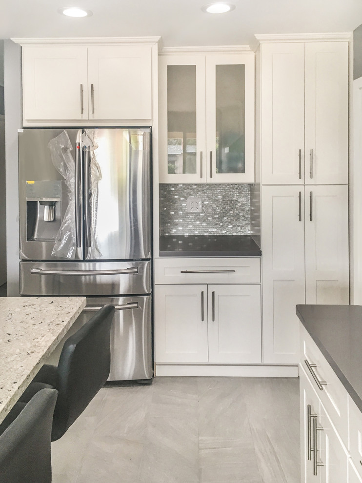 Idéer för ett mellanstort modernt grå kök, med en rustik diskho, skåp i shakerstil, vita skåp, bänkskiva i kvarts, flerfärgad stänkskydd, stänkskydd i mosaik, rostfria vitvaror, klinkergolv i porslin, en köksö och grått golv