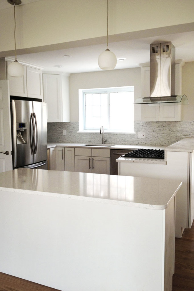 Example of a mid-sized trendy u-shaped medium tone wood floor and brown floor open concept kitchen design in Other with an undermount sink, shaker cabinets, white cabinets, quartz countertops, gray backsplash, stainless steel appliances and an island