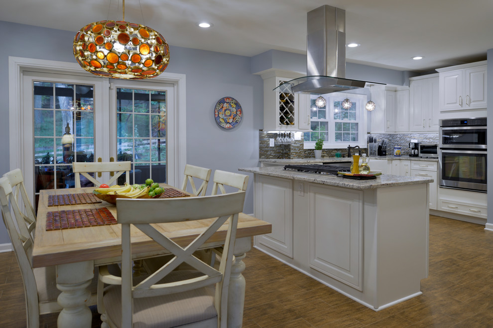 Example of a mid-sized trendy u-shaped laminate floor and brown floor eat-in kitchen design in Other with an undermount sink, raised-panel cabinets, white cabinets, granite countertops, multicolored backsplash, matchstick tile backsplash, stainless steel appliances and no island