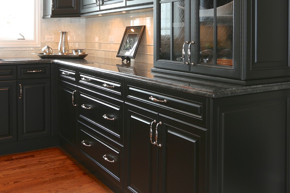 Inspiration for a large traditional u-shaped enclosed kitchen in Chicago with a double-bowl sink, raised-panel cabinets, black cabinets, white splashback, stainless steel appliances, medium hardwood flooring and an island.