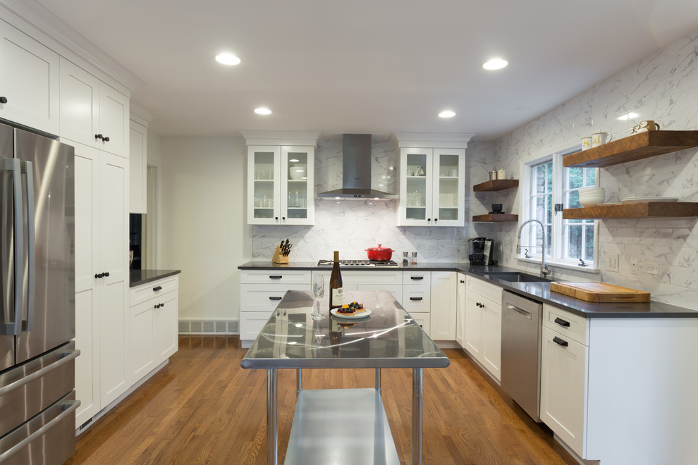 Exempel på ett mellanstort modernt kök, med en undermonterad diskho, skåp i shakerstil, vita skåp, granitbänkskiva, vitt stänkskydd, stänkskydd i marmor, rostfria vitvaror, mellanmörkt trägolv och en köksö