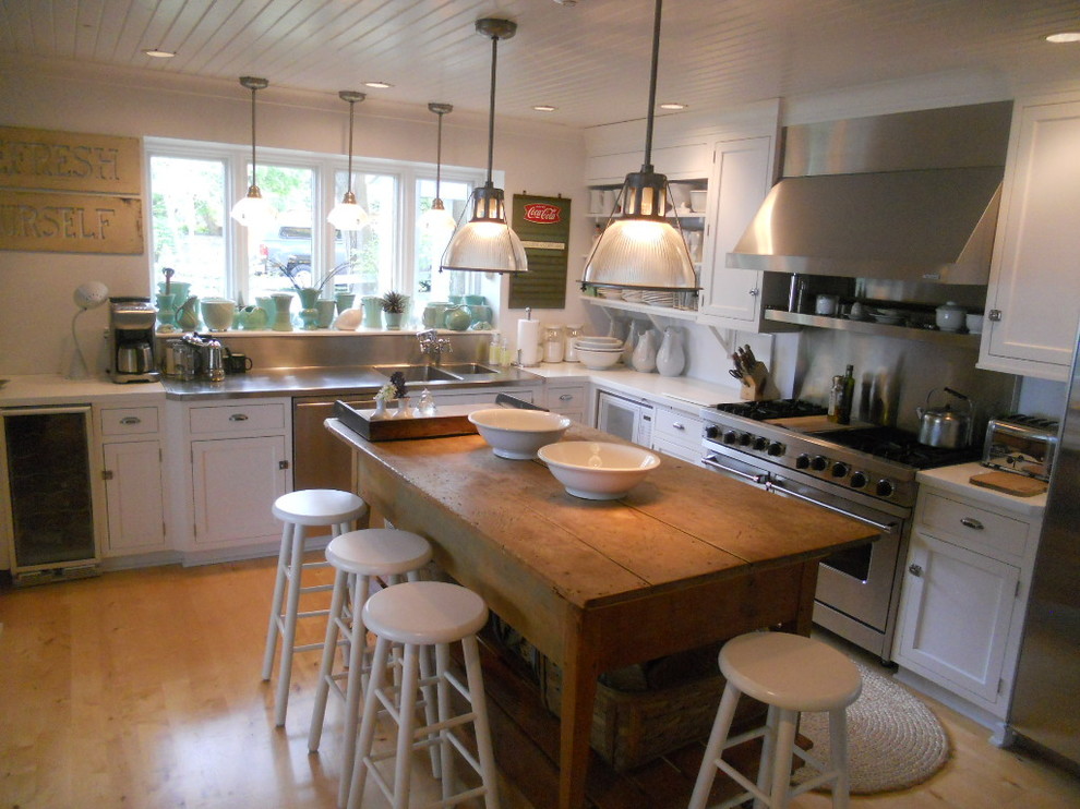 Example of a large urban u-shaped light wood floor and beige floor open concept kitchen design in Milwaukee with an integrated sink, shaker cabinets, white cabinets, wood countertops, metallic backsplash, metal backsplash, stainless steel appliances and an island