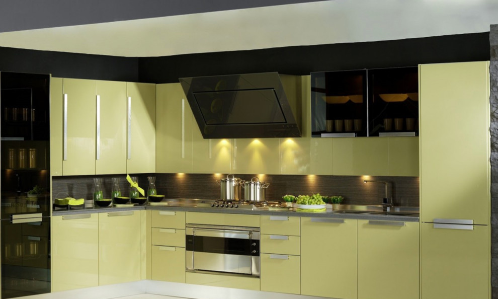 Diseño de cocina actual grande con fregadero integrado, armarios con paneles lisos, puertas de armario amarillas, salpicadero negro, electrodomésticos negros, suelo de cemento y suelo gris
