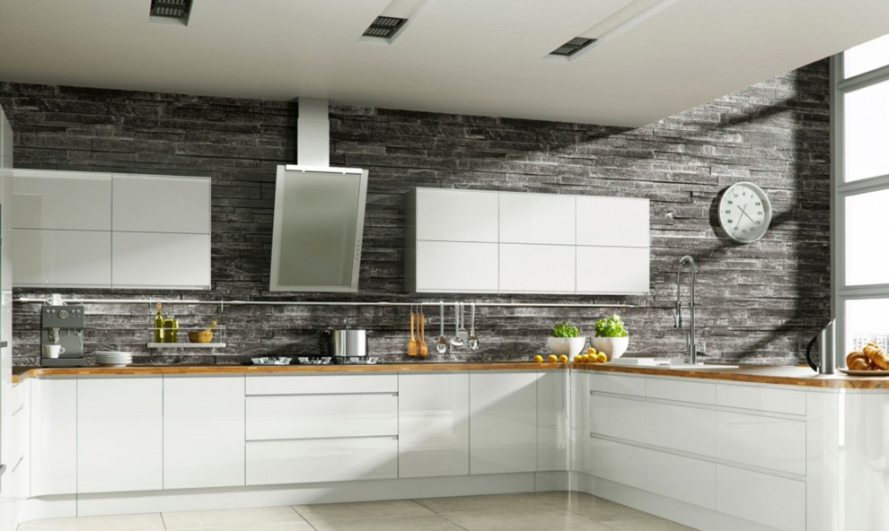 Large contemporary u-shaped enclosed kitchen in Los Angeles with a built-in sink, flat-panel cabinets, white cabinets, wood worktops, grey splashback, stone tiled splashback, stainless steel appliances, travertine flooring, a breakfast bar and beige floors.