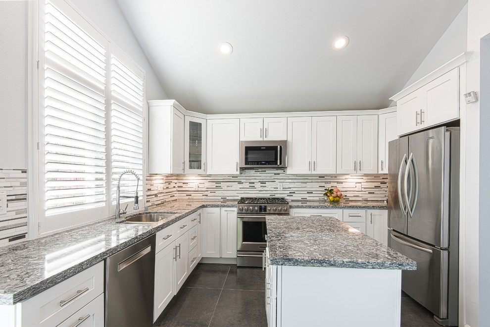 Mid-sized transitional l-shaped porcelain tile and gray floor eat-in kitchen photo in San Francisco with an undermount sink, shaker cabinets, white cabinets, quartz countertops, multicolored backsplash, mosaic tile backsplash, stainless steel appliances and an island
