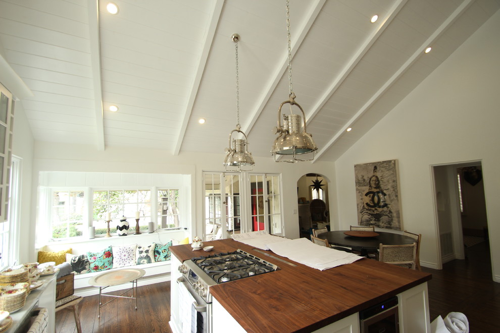 Immagine di una cucina chic di medie dimensioni con ante in stile shaker, ante bianche, top in legno, elettrodomestici in acciaio inossidabile e parquet scuro