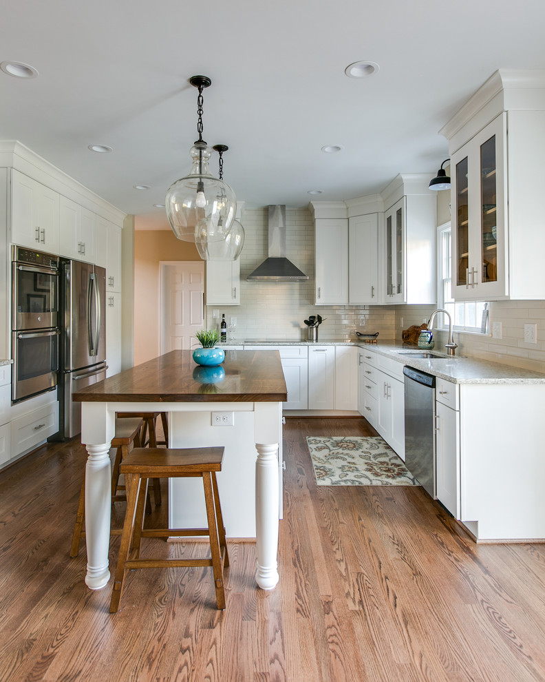 Geschlossene Moderne Küche in L-Form mit Schrankfronten mit vertiefter Füllung, weißen Schränken, Küchenrückwand in Weiß, Küchengeräten aus Edelstahl, hellem Holzboden und Kücheninsel in Baltimore