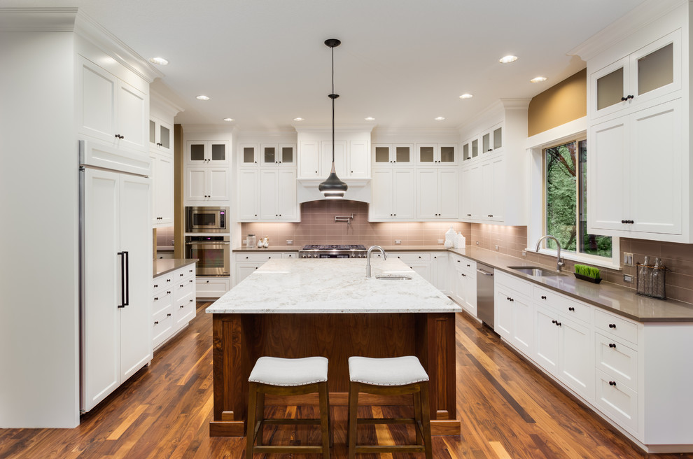 Example of a large classic u-shaped medium tone wood floor and brown floor eat-in kitchen design in Seattle with a single-bowl sink, shaker cabinets, white cabinets, quartzite countertops, brown backsplash, glass tile backsplash, stainless steel appliances, an island and brown countertops