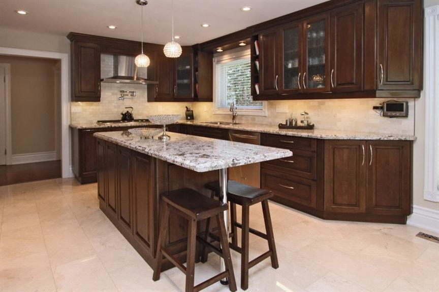 Photo of a medium sized traditional u-shaped kitchen/diner in Toronto with a double-bowl sink, raised-panel cabinets, granite worktops, beige splashback, stone tiled splashback, stainless steel appliances, marble flooring, an island and dark wood cabinets.