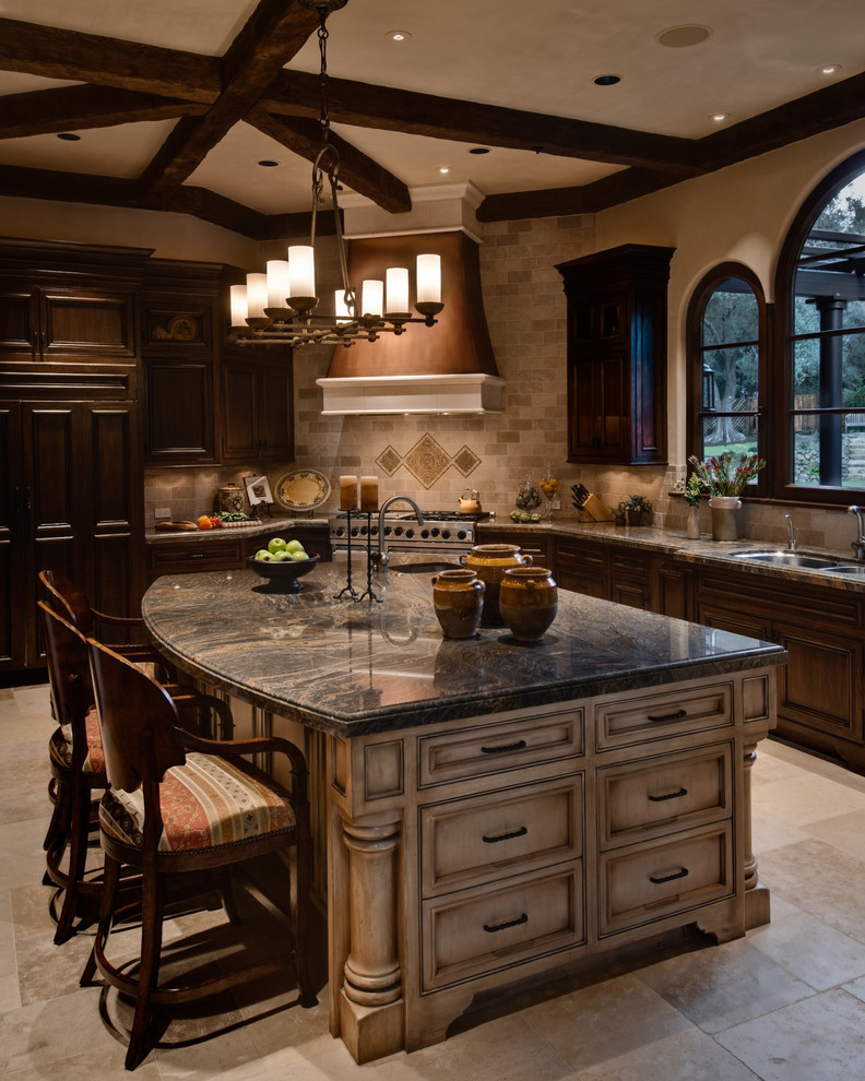 Inspiration for a large mediterranean l-shaped travertine floor and beige floor open concept kitchen remodel in San Francisco with an undermount sink, recessed-panel cabinets, beige cabinets, marble countertops, beige backsplash, travertine backsplash, stainless steel appliances and an island