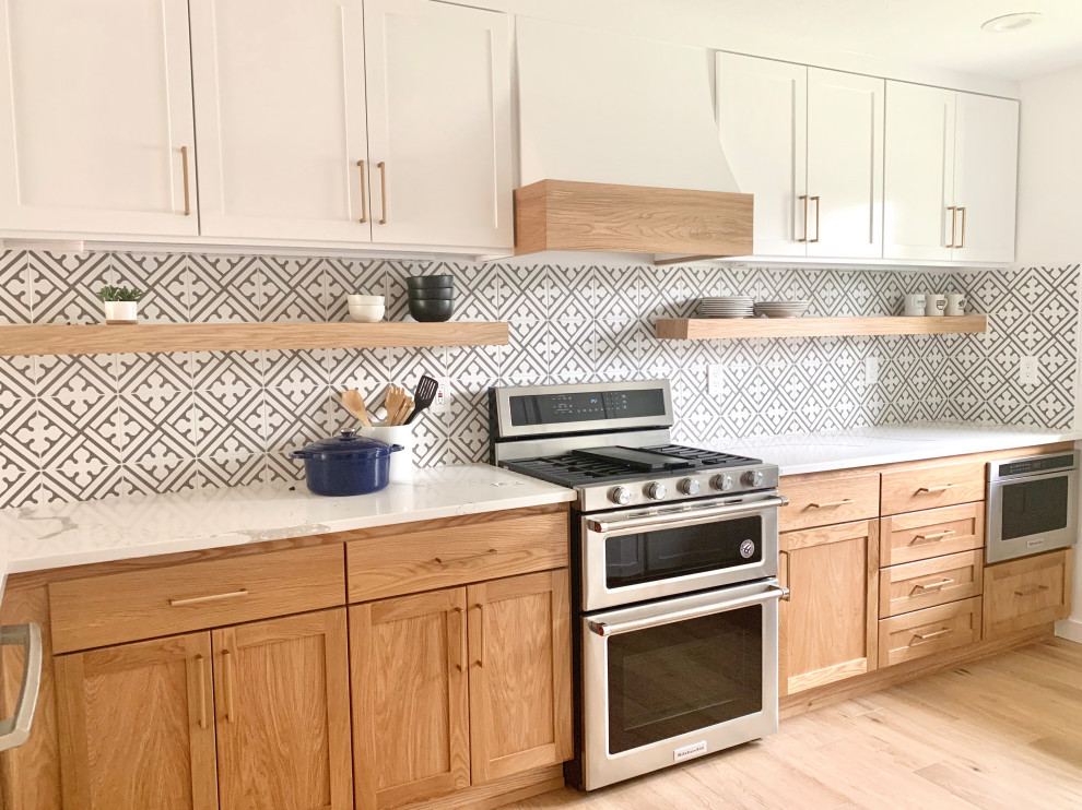 Example of a mid-sized trendy l-shaped light wood floor and beige floor enclosed kitchen design in Portland with an undermount sink, shaker cabinets, light wood cabinets, quartz countertops, gray backsplash, ceramic backsplash, a peninsula and white countertops
