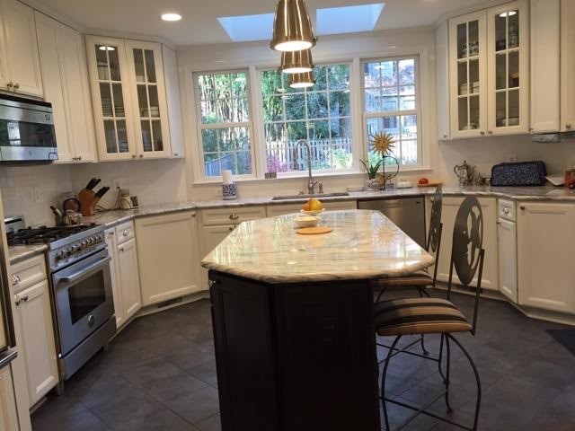 Example of a large transitional u-shaped ceramic tile enclosed kitchen design in DC Metro with an undermount sink, recessed-panel cabinets, yellow cabinets, granite countertops, white backsplash, subway tile backsplash, stainless steel appliances and an island