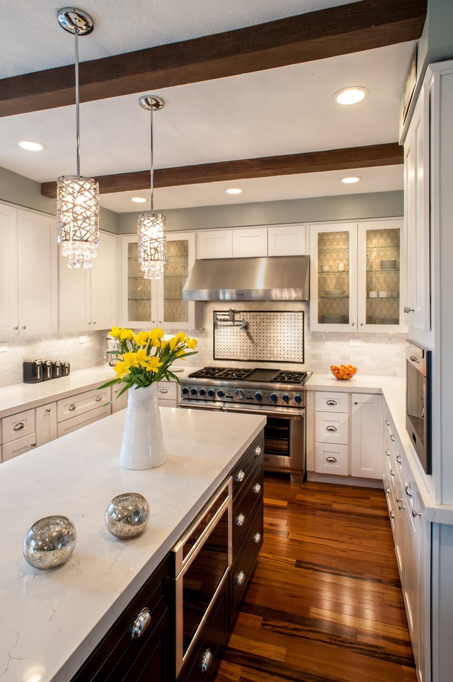 Kitchen - transitional u-shaped kitchen idea in Los Angeles with shaker cabinets, white cabinets and white backsplash