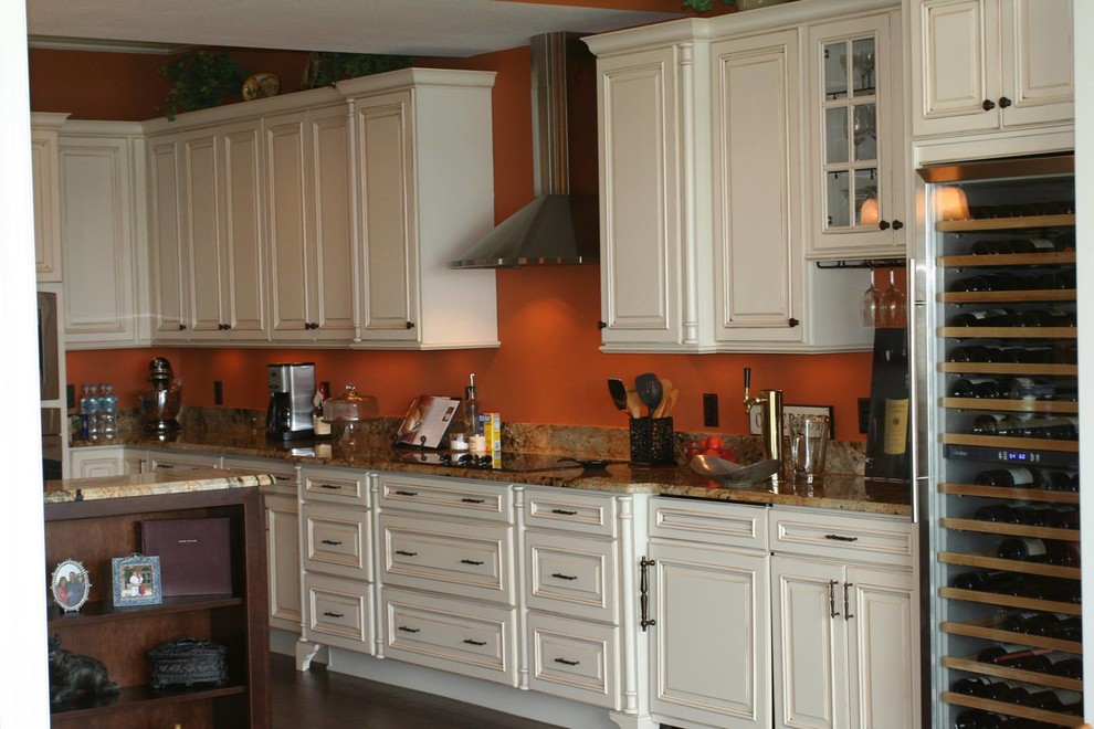 Exempel på ett mellanstort maritimt kök, med en nedsänkt diskho, luckor med upphöjd panel, vita skåp, granitbänkskiva, orange stänkskydd, rostfria vitvaror, mörkt trägolv och en köksö