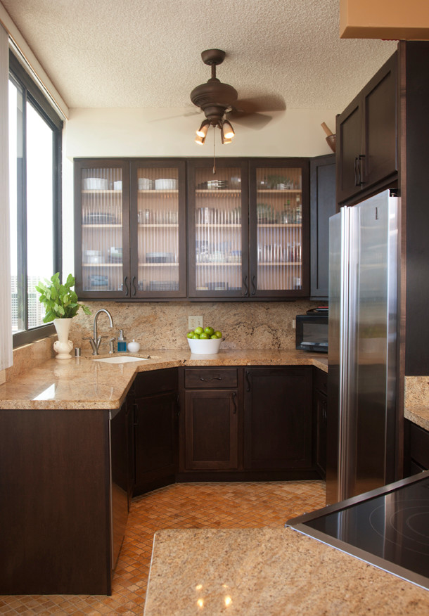 Moderne Wohnküche mit Unterbauwaschbecken, Glasfronten, dunklen Holzschränken, Küchengeräten aus Edelstahl und Keramikboden in Hawaii