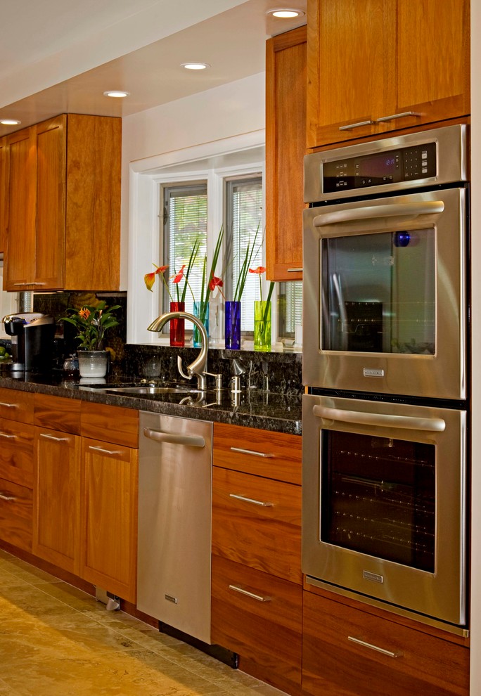 Immagine di una cucina abitabile contemporanea con lavello sottopiano, ante in legno scuro, paraspruzzi nero e elettrodomestici in acciaio inossidabile
