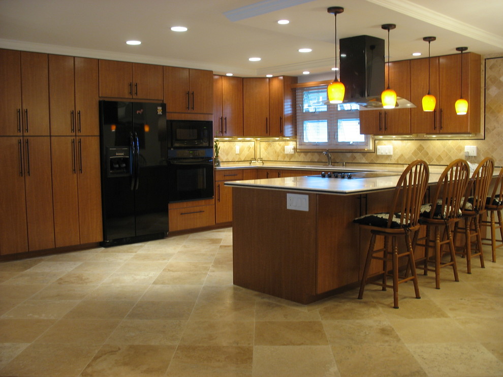 Cette image montre une cuisine américaine design en U et bois brun avec un évier encastré, un placard à porte plane, une crédence multicolore et un électroménager noir.