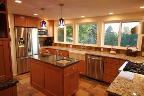 Example of a mid-sized trendy u-shaped ceramic tile enclosed kitchen design in Seattle with a farmhouse sink, recessed-panel cabinets, medium tone wood cabinets, granite countertops, multicolored backsplash, ceramic backsplash, stainless steel appliances and an island