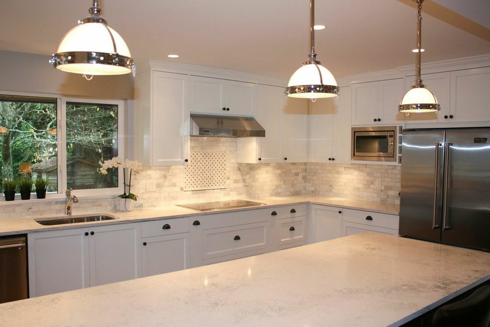 Inspiration for a large classic l-shaped kitchen/diner in Vancouver with a submerged sink, shaker cabinets, white cabinets, engineered stone countertops, white splashback, marble splashback, stainless steel appliances, medium hardwood flooring, an island and brown floors.