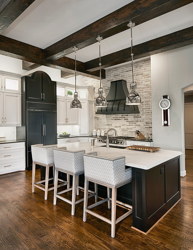 Klassische Küche in L-Form mit Schrankfronten im Shaker-Stil, weißen Schränken, Küchenrückwand in Grau, dunklem Holzboden, Kücheninsel und Elektrogeräten mit Frontblende in Dallas