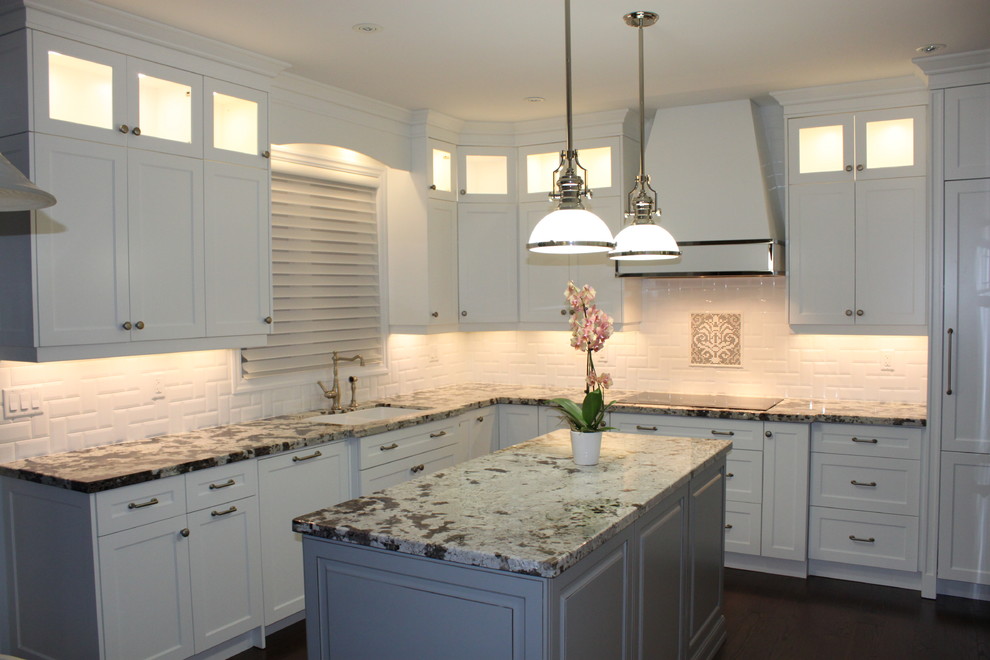 Mid-sized transitional l-shaped medium tone wood floor eat-in kitchen photo in Toronto with an undermount sink, recessed-panel cabinets, white cabinets, granite countertops, white backsplash, subway tile backsplash and paneled appliances
