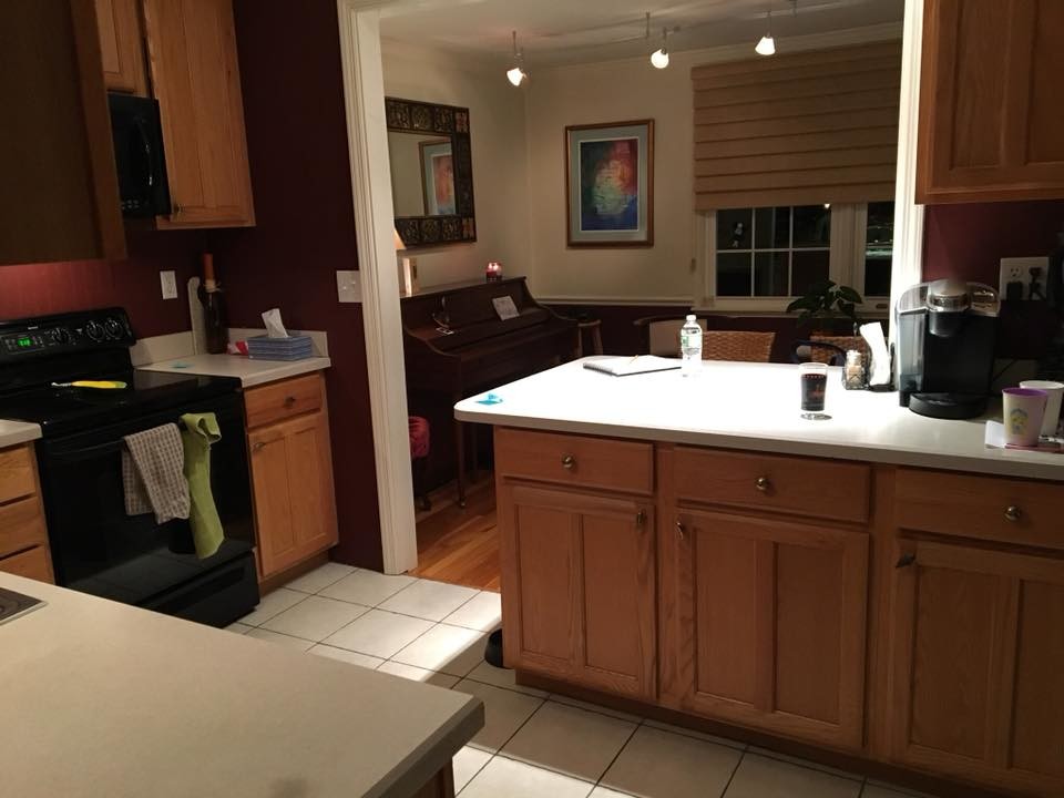 Bild på ett avskilt, stort lantligt vit vitt u-kök, med en rustik diskho, skåp i shakerstil, vita skåp, bänkskiva i kvarts, vitt stänkskydd, stänkskydd i keramik, rostfria vitvaror, mörkt trägolv, en köksö och brunt golv