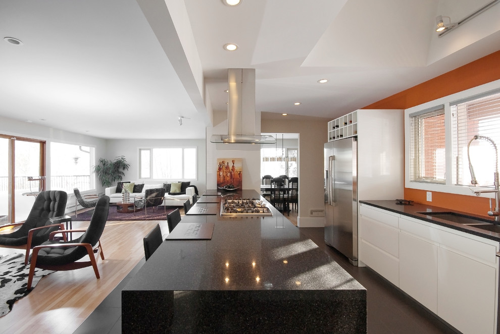 Photo of a contemporary galley open plan kitchen in Other with a double-bowl sink, engineered stone countertops and a feature wall.