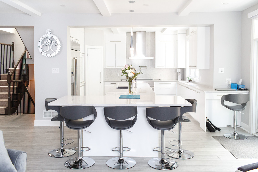 Example of a mid-sized trendy gray floor open concept kitchen design in Ottawa with an undermount sink, flat-panel cabinets, white cabinets, quartz countertops, stainless steel appliances, an island, white countertops, gray backsplash and stone slab backsplash