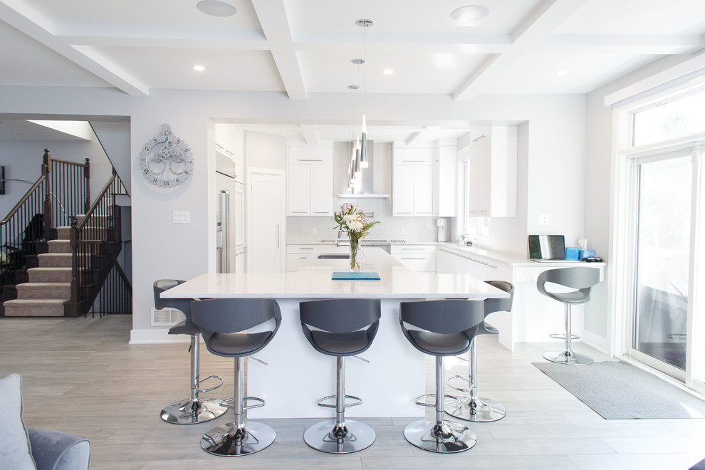 Example of a mid-sized trendy u-shaped ceramic tile and gray floor kitchen design in Ottawa with an undermount sink, flat-panel cabinets, white cabinets, quartz countertops, white backsplash, stainless steel appliances, an island and white countertops
