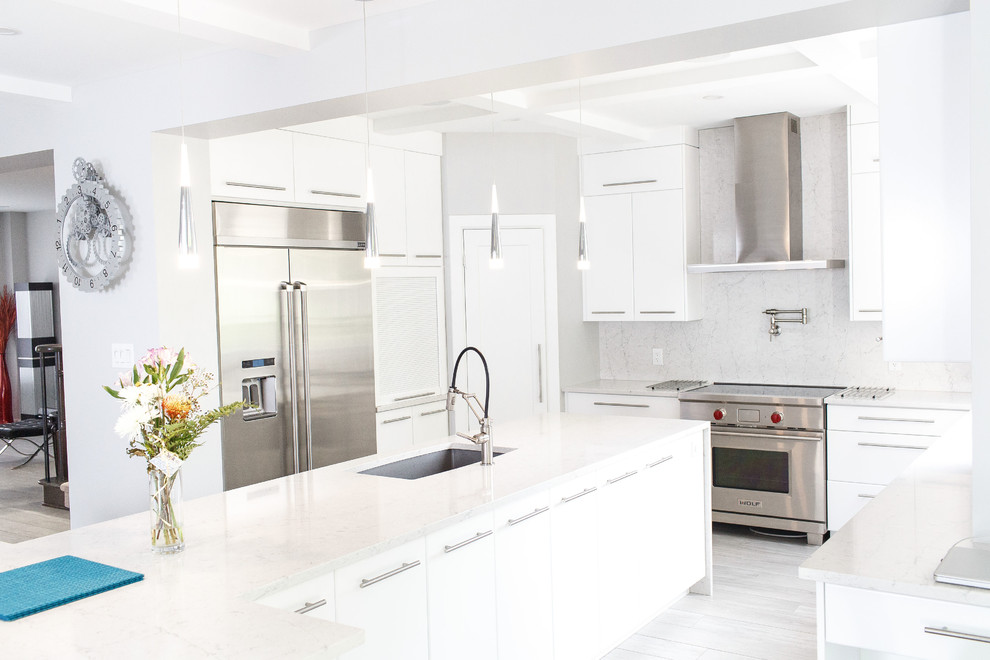 Mid-sized trendy u-shaped ceramic tile and gray floor kitchen photo in Ottawa with an undermount sink, flat-panel cabinets, white cabinets, quartz countertops, white backsplash, stainless steel appliances, an island and white countertops