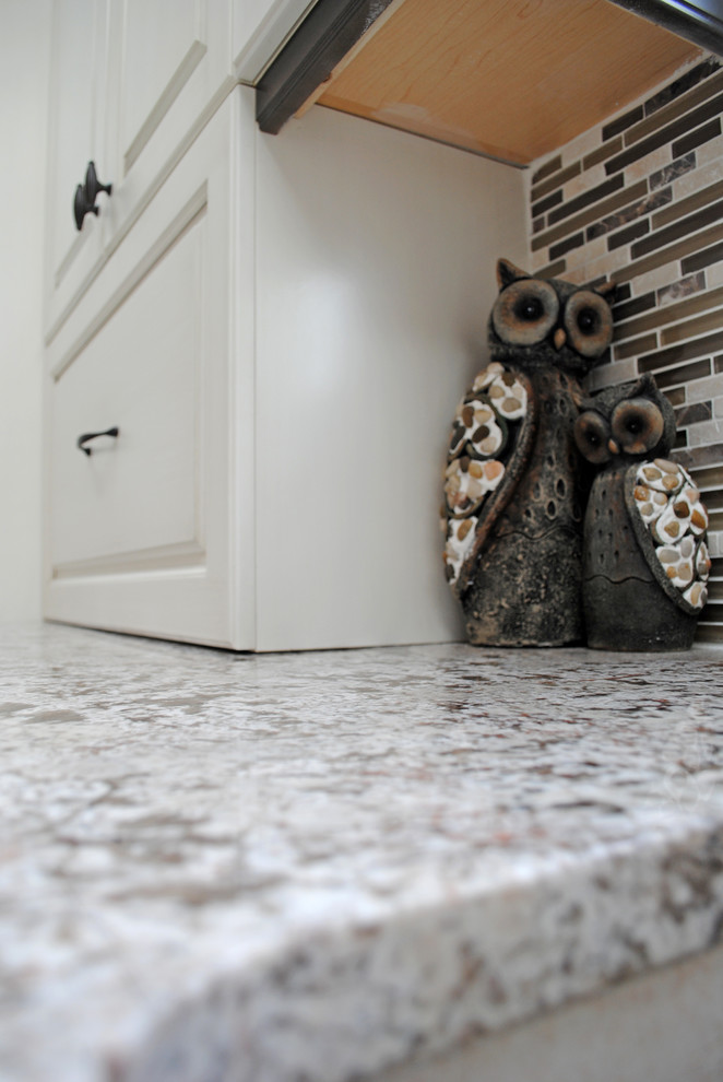 Mittelgroße Moderne Wohnküche in L-Form mit Unterbauwaschbecken, profilierten Schrankfronten, weißen Schränken, Granit-Arbeitsplatte, bunter Rückwand, Rückwand aus Mosaikfliesen, Küchengeräten aus Edelstahl, Keramikboden und Kücheninsel in Calgary