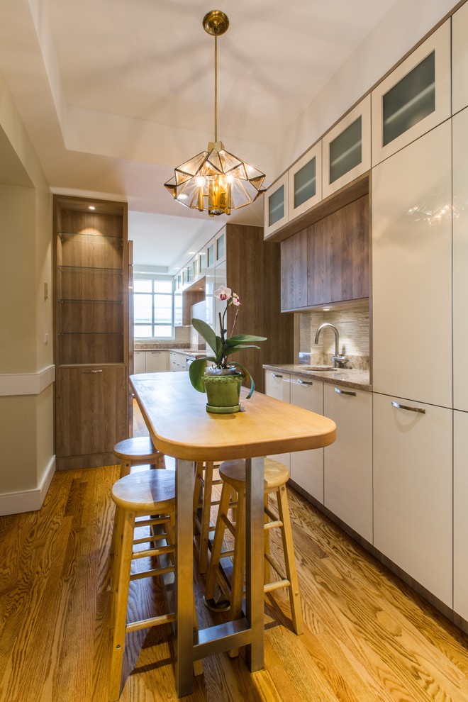 Inspiration for a small transitional galley light wood floor eat-in kitchen remodel in New York with flat-panel cabinets, beige cabinets, granite countertops, beige backsplash, matchstick tile backsplash, stainless steel appliances and no island