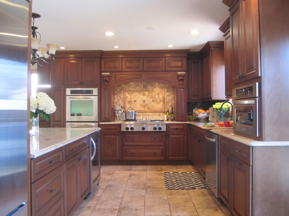 Kitchen - large traditional l-shaped ceramic tile kitchen idea in Chicago with an undermount sink, recessed-panel cabinets, medium tone wood cabinets, granite countertops, beige backsplash, mosaic tile backsplash, stainless steel appliances and an island