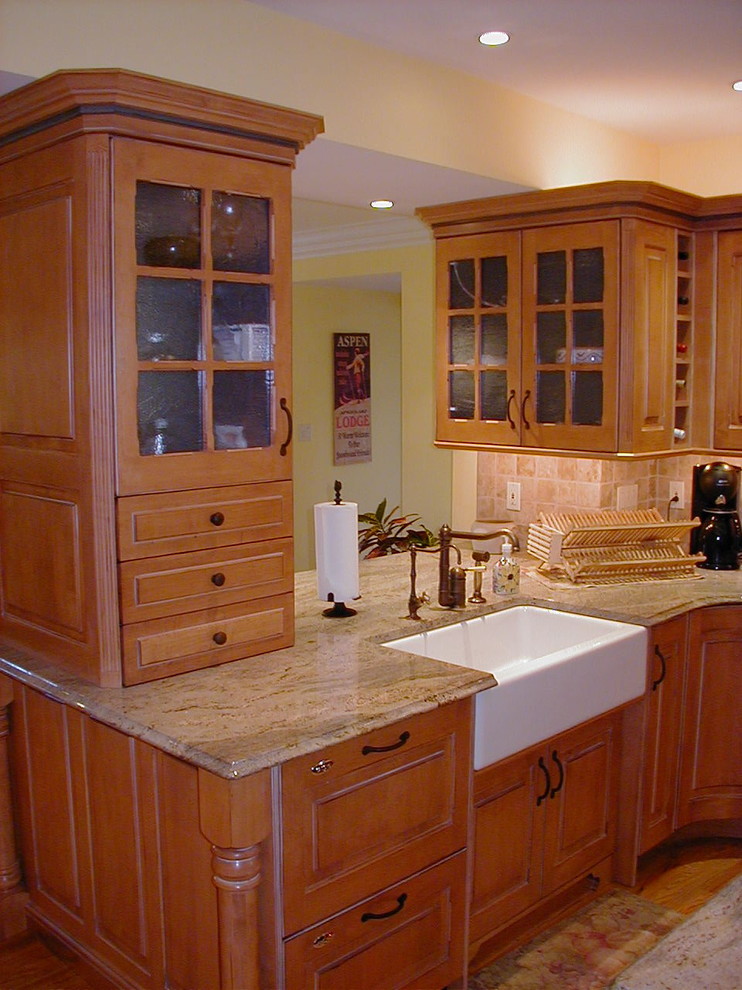 Idéer för att renovera ett stort lantligt kök, med en rustik diskho, luckor med upphöjd panel, skåp i mellenmörkt trä, granitbänkskiva, beige stänkskydd, stänkskydd i stenkakel, rostfria vitvaror, mellanmörkt trägolv och en köksö