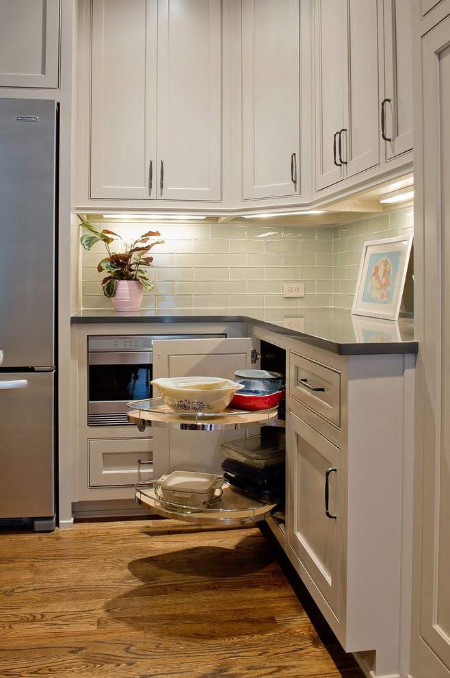 Exempel på ett mellanstort klassiskt kök, med en undermonterad diskho, skåp i shakerstil, vita skåp, marmorbänkskiva, blått stänkskydd, stänkskydd i glaskakel, rostfria vitvaror, mellanmörkt trägolv och en köksö