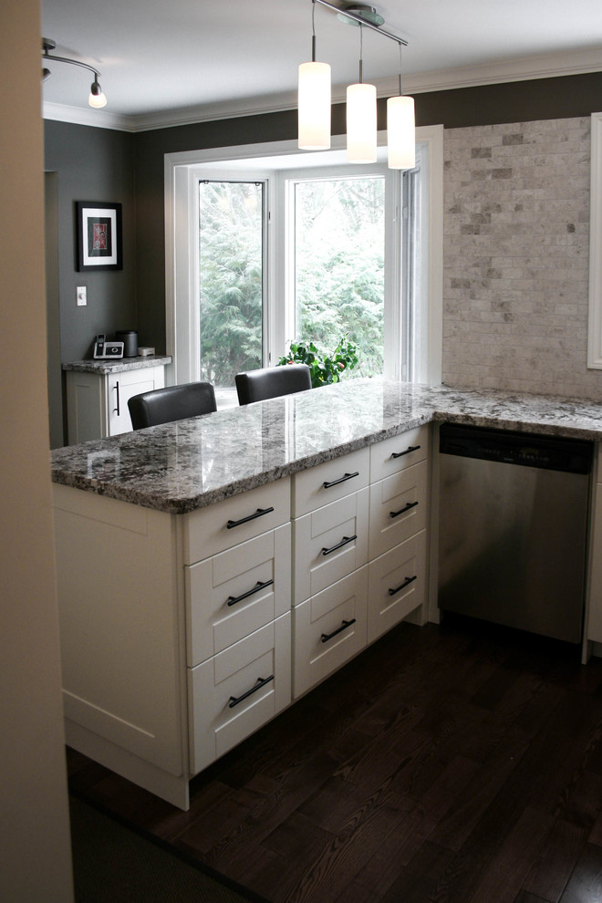 Exempel på ett mellanstort klassiskt kök, med en undermonterad diskho, skåp i shakerstil, vita skåp, granitbänkskiva, grått stänkskydd, stänkskydd i tunnelbanekakel, rostfria vitvaror och mörkt trägolv