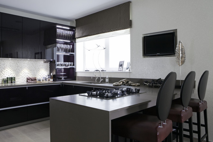Exempel på ett mellanstort modernt u-kök, med en undermonterad diskho, släta luckor, svarta skåp, vitt stänkskydd, stänkskydd i stenkakel, integrerade vitvaror, ljust trägolv, en halv köksö och brunt golv