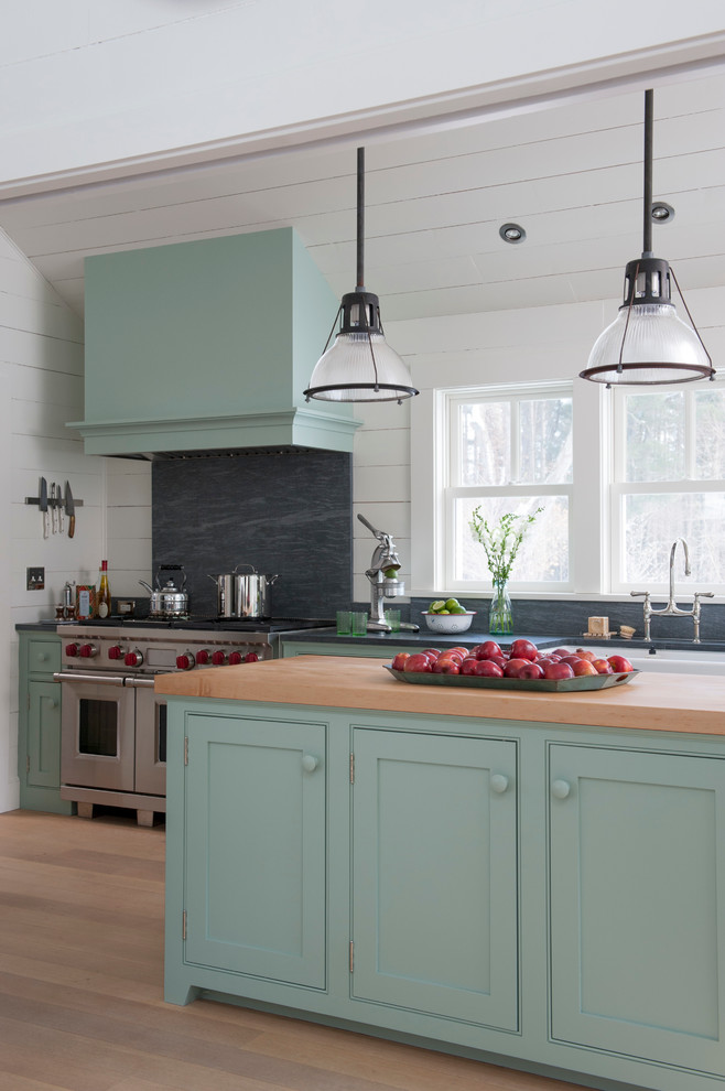 Example of a cottage kitchen design in Bridgeport with a farmhouse sink, beaded inset cabinets, blue cabinets, wood countertops, gray backsplash and stainless steel appliances