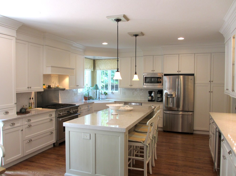 Foto de cocina de estilo de casa de campo de tamaño medio con fregadero sobremueble, puertas de armario blancas, una isla y suelo marrón