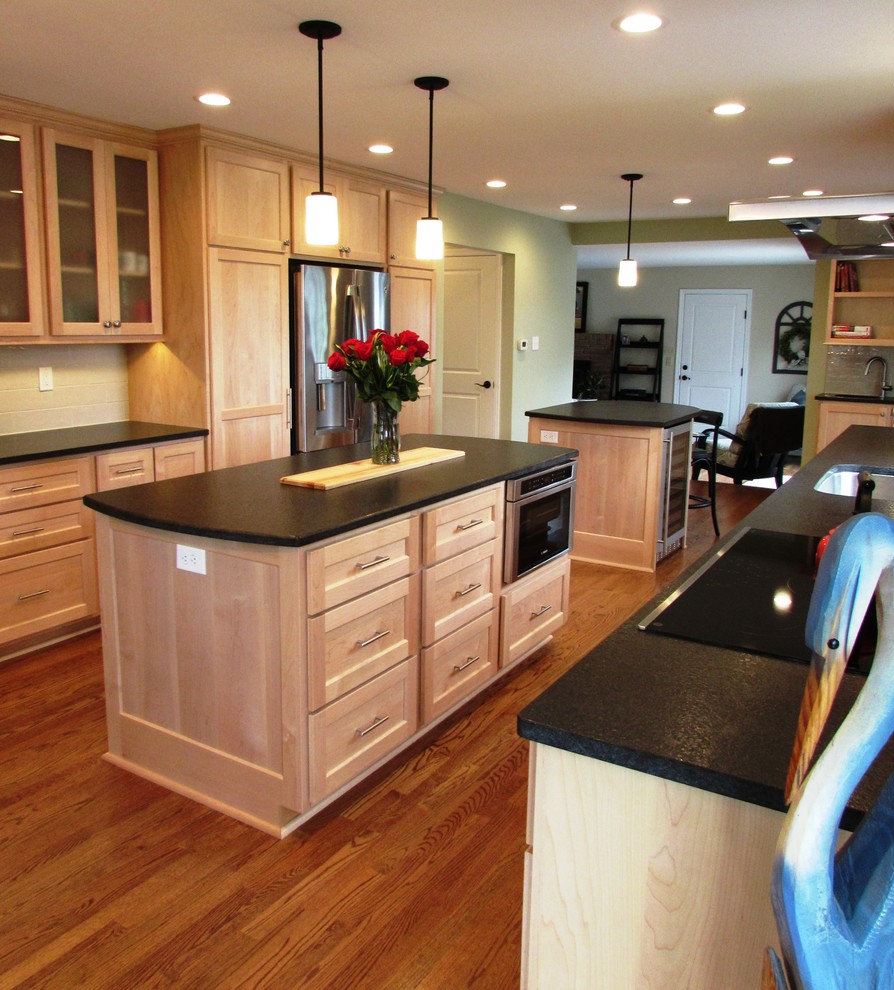Klassisk inredning av ett mellanstort kök, med en undermonterad diskho, luckor med upphöjd panel, skåp i ljust trä, bänkskiva i koppar, grått stänkskydd, stänkskydd i keramik, rostfria vitvaror, mellanmörkt trägolv, flera köksöar och brunt golv