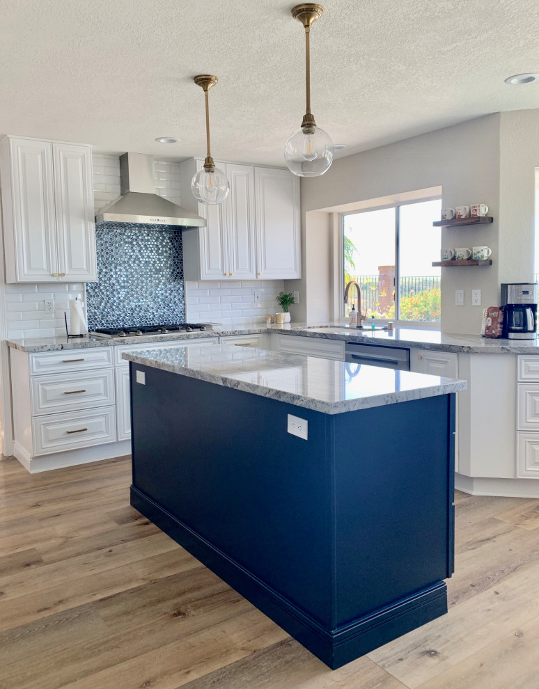 Design ideas for a large traditional kitchen in San Diego with a submerged sink, raised-panel cabinets, white cabinets, granite worktops, blue splashback, mosaic tiled splashback, stainless steel appliances, vinyl flooring, an island and multicoloured worktops.