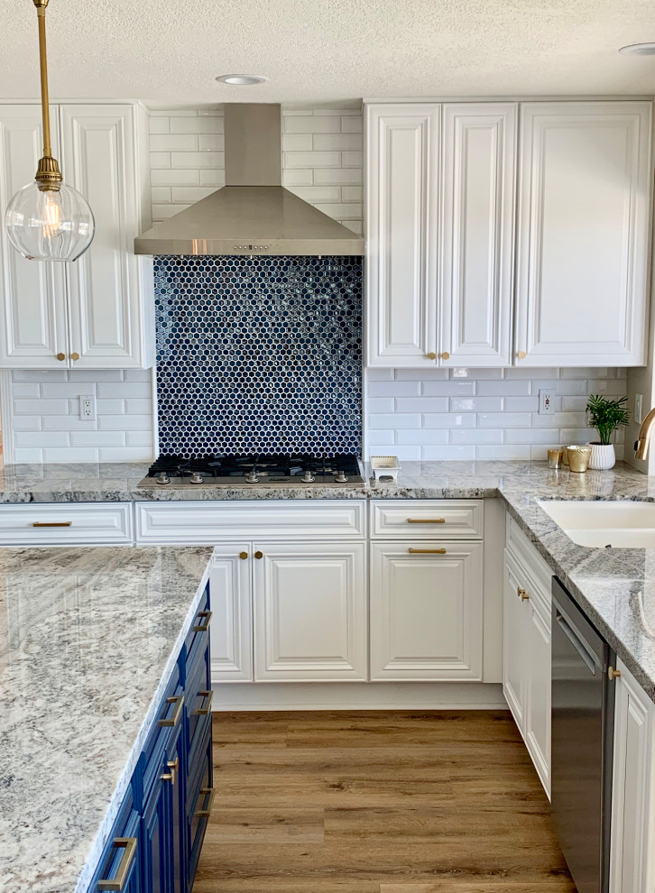 Inredning av ett klassiskt stort flerfärgad flerfärgat kök, med en undermonterad diskho, luckor med upphöjd panel, vita skåp, granitbänkskiva, blått stänkskydd, stänkskydd i mosaik, rostfria vitvaror, vinylgolv och en köksö